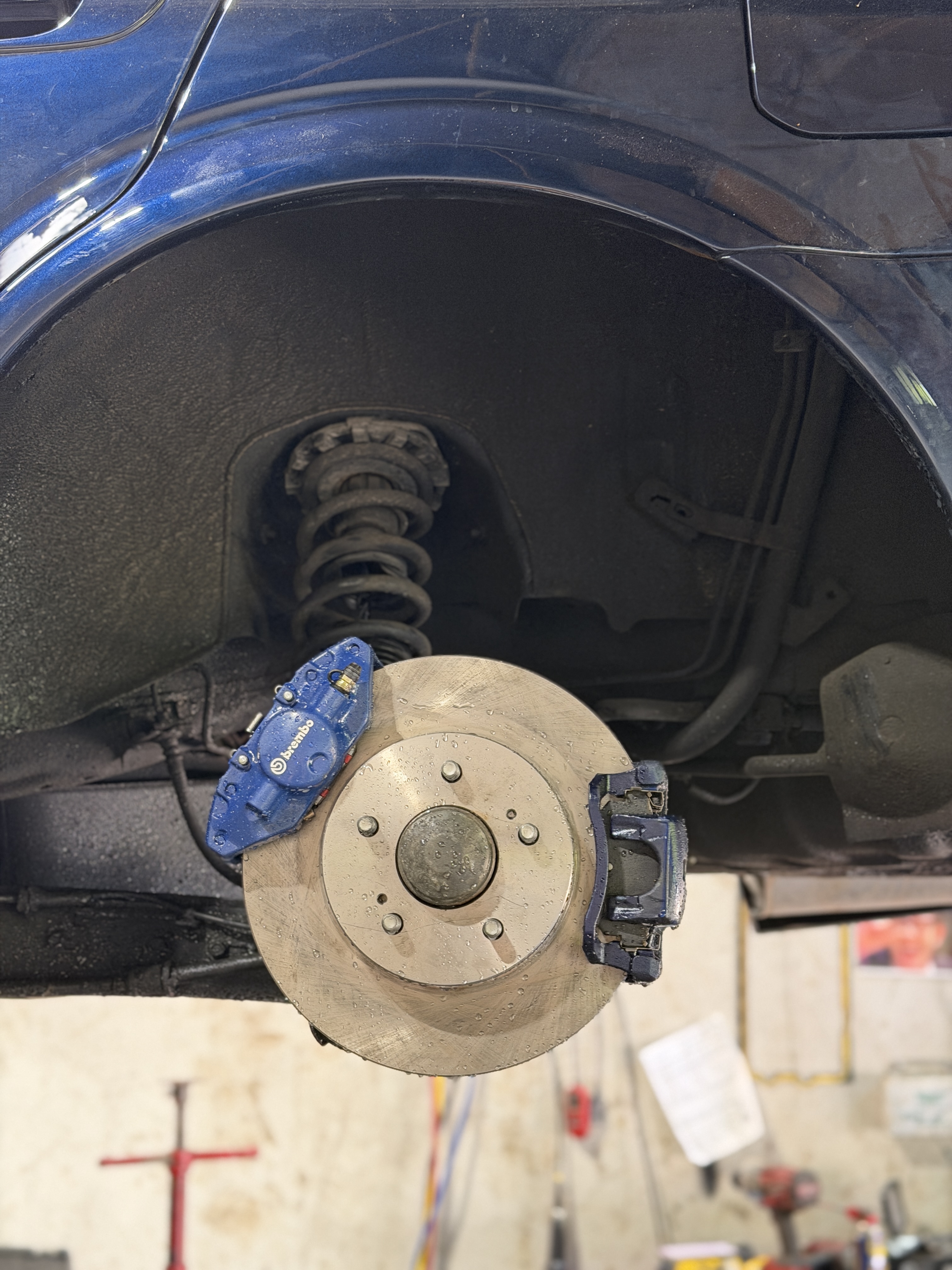 Blue Brembo 4-piston caliper from Nissan 350Z installed on 2002 Nissan Maxima — custom brake swap at Street Motors Toronto