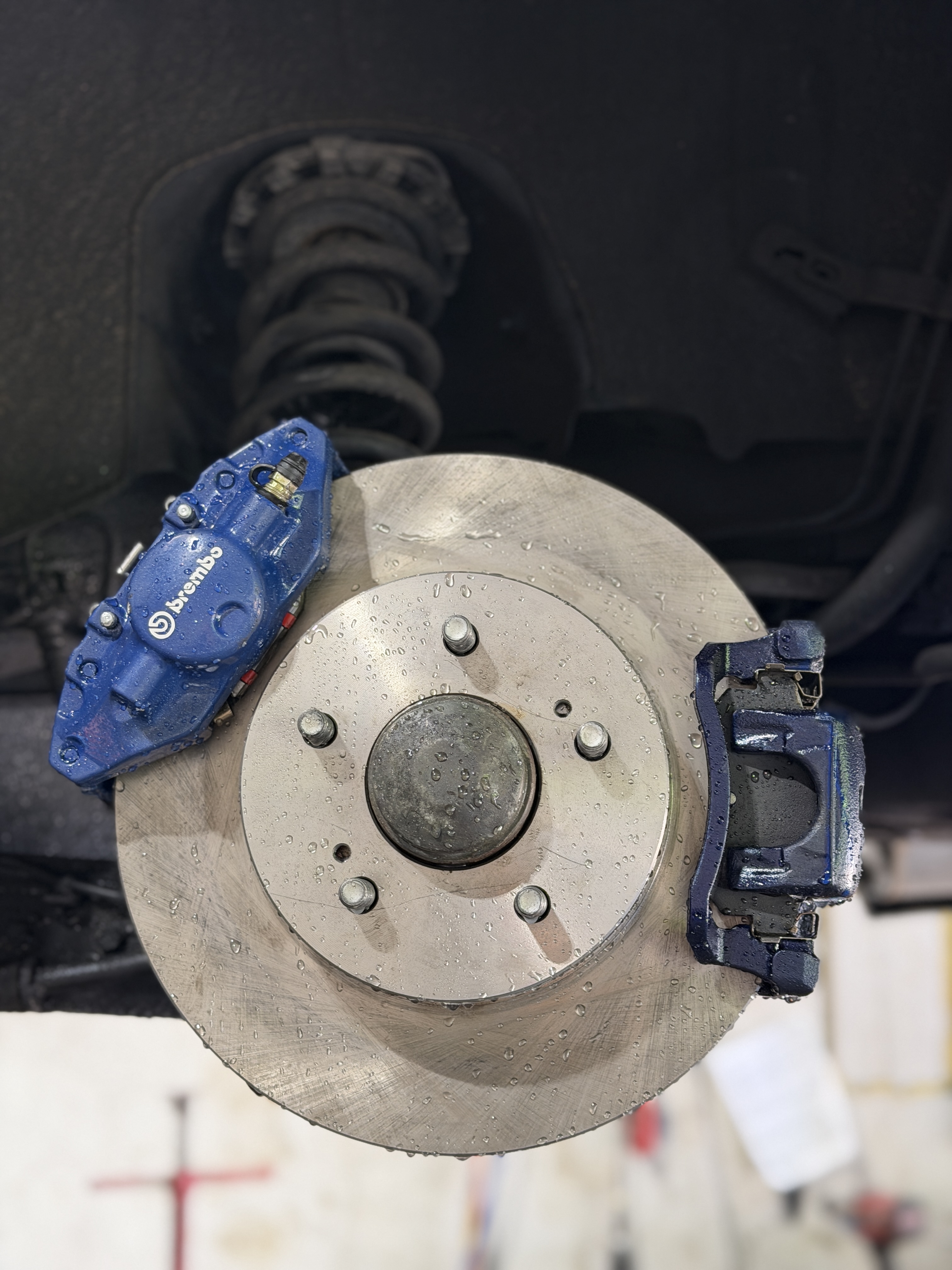 2002 Nissan Maxima on hoist at Street Motors Toronto — Nissan 350Z Brembo caliper conversion visible from wheel arch